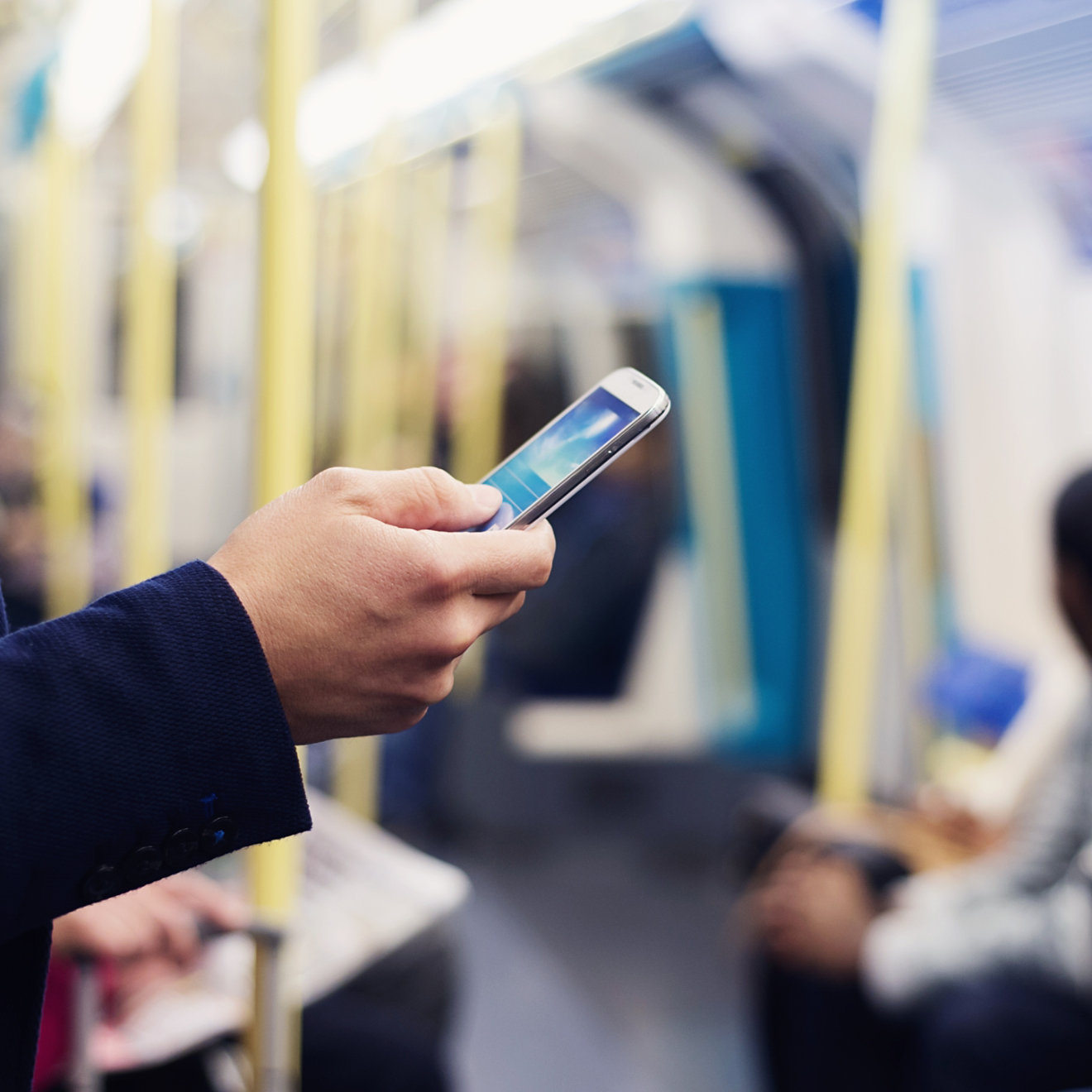 Young handsome businessman with smartphone in subway