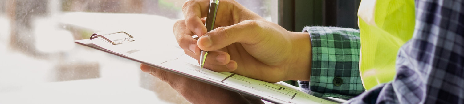 Young man contractor, engineering or employee holding, clipboard, looking at paperwork on the inspecting the reconstructed construction and renovation after to check defect of apartment,home at site.