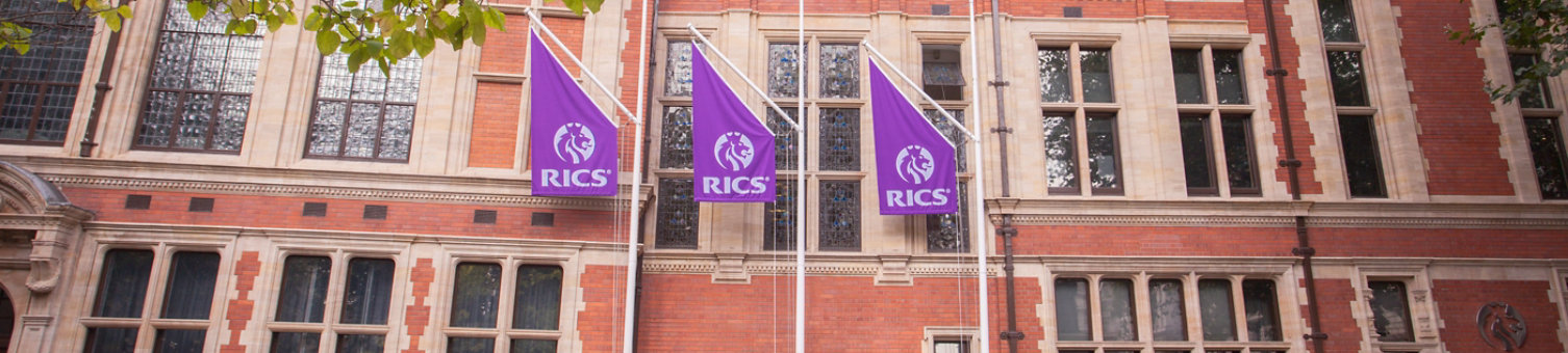 The outside of the RICS headquarters in London with three purple RICS flags flying