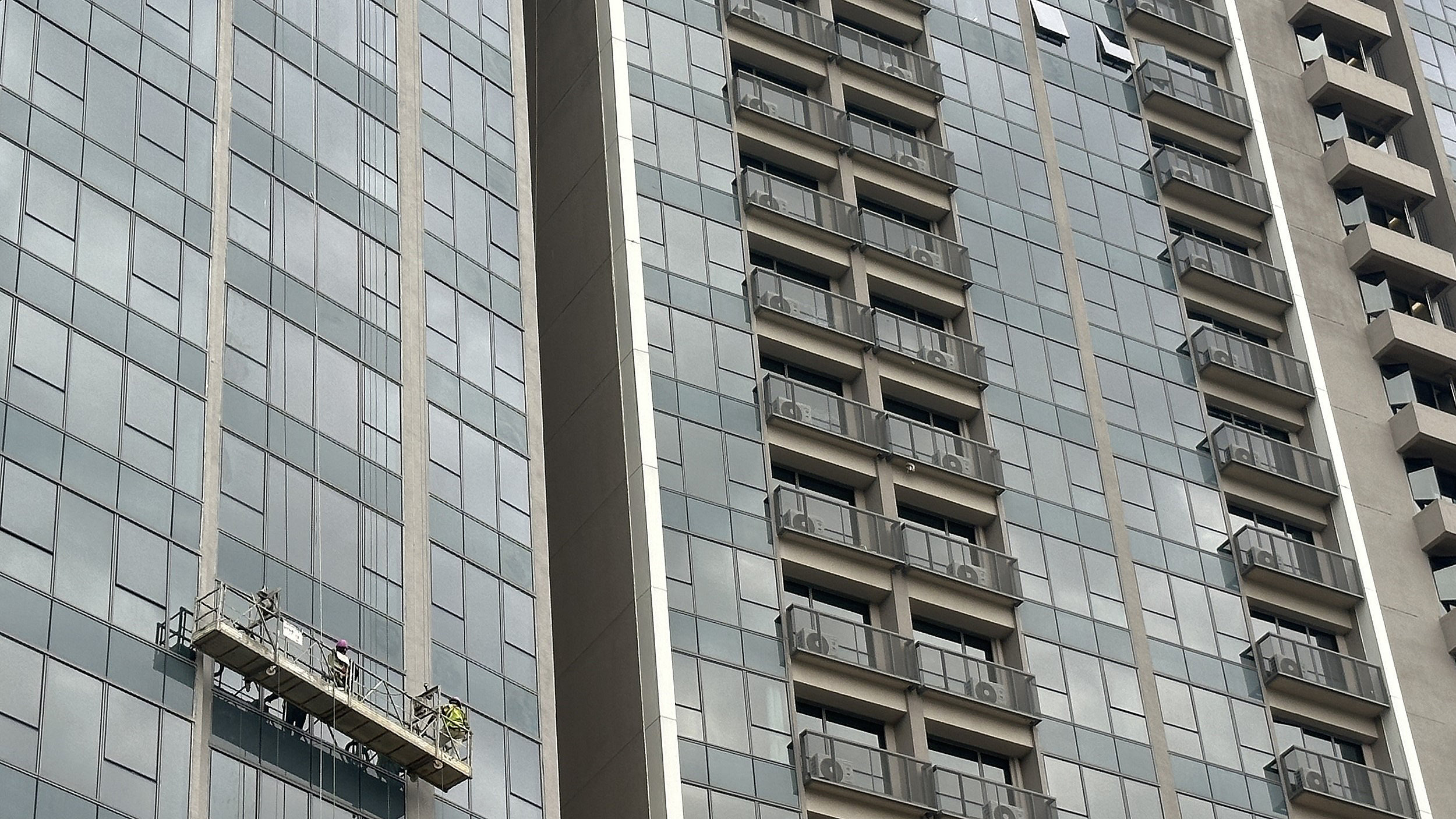 Workers on high rise facade