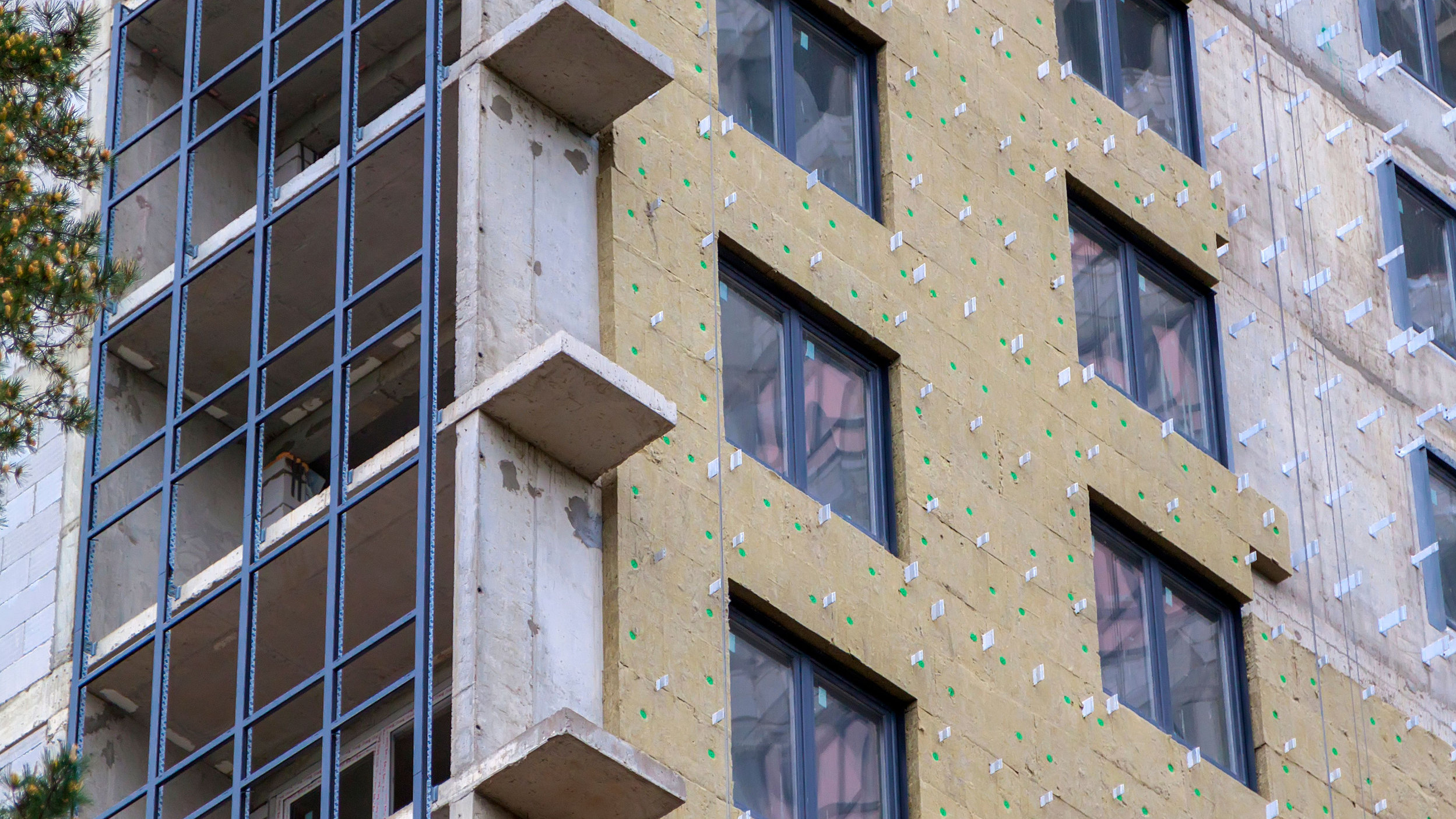 Picture of high rise in process of being built, we can see the metal girders and insulation panelling