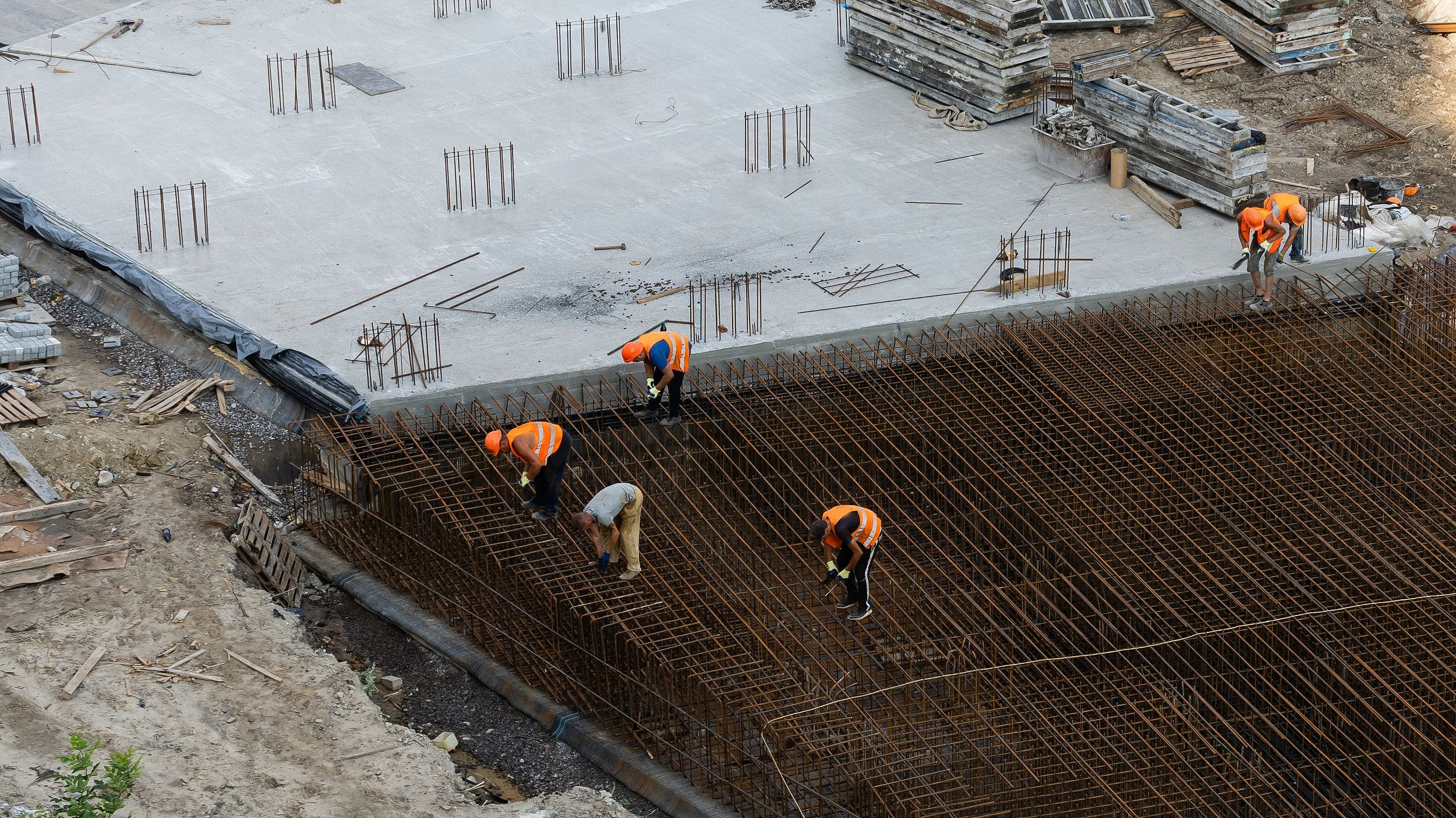 Overhead photo of construction workers on site after concrete pour of foundations
