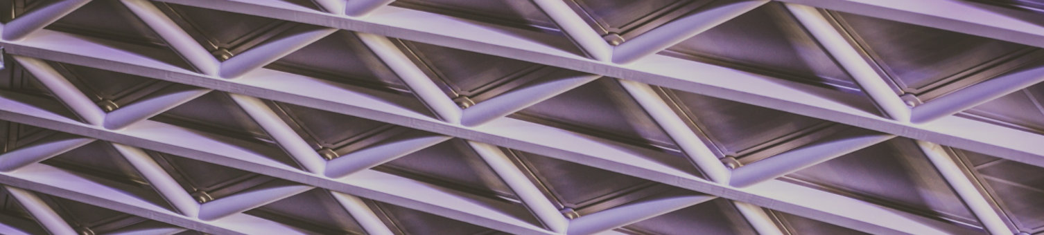 A lattice architectural window structure lit with purple and blue lights