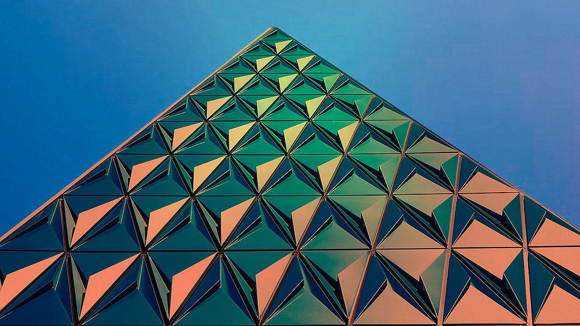 Triangle glass building against blue sky