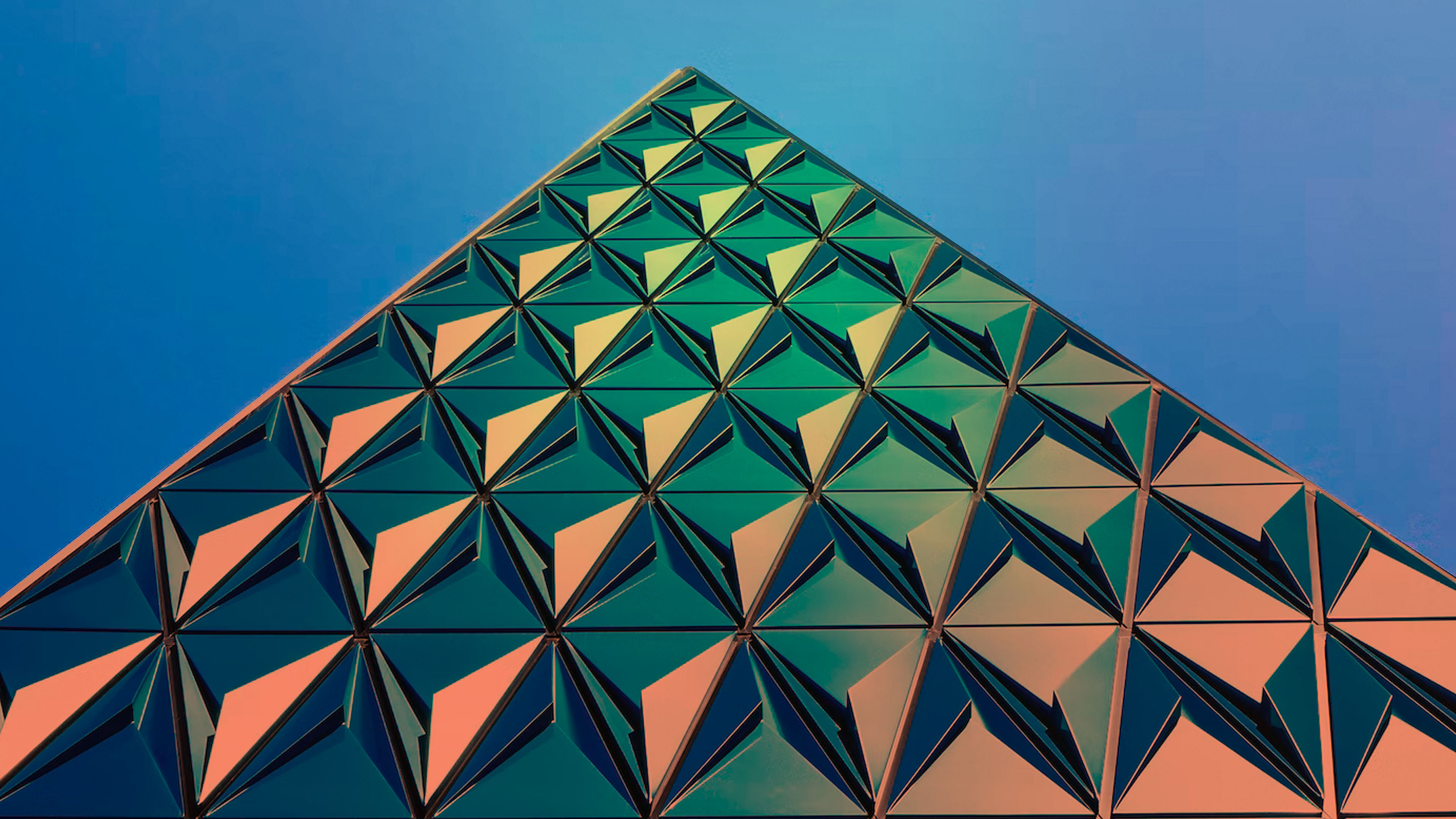 Triangle glass building against blue sky