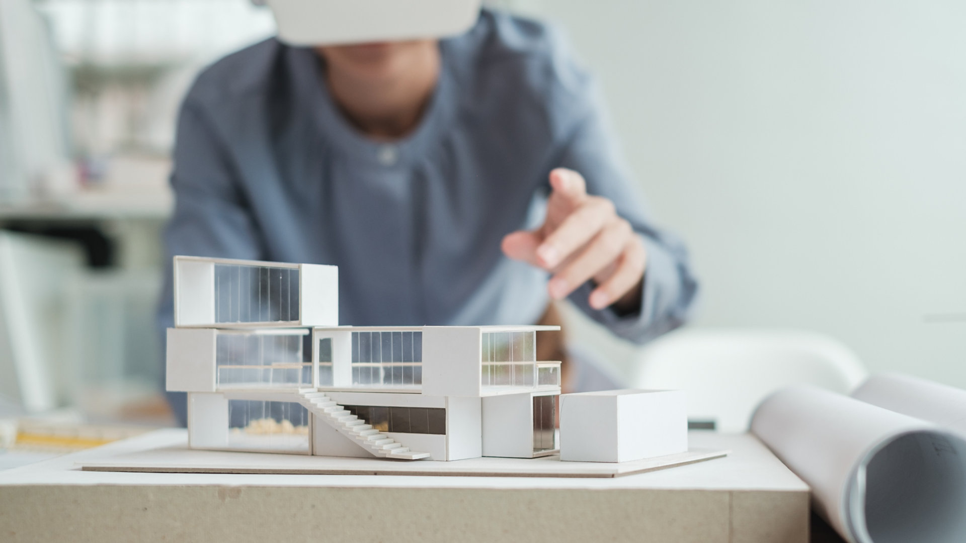 Person working on model architecture with a VR headset 