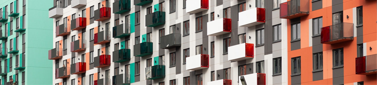 A cluster of contemporary high-rise apartment buildings showcases vibrant facades and balconies in a bustling residential area under cloudy skies. Residents enjoy urban living amenities.