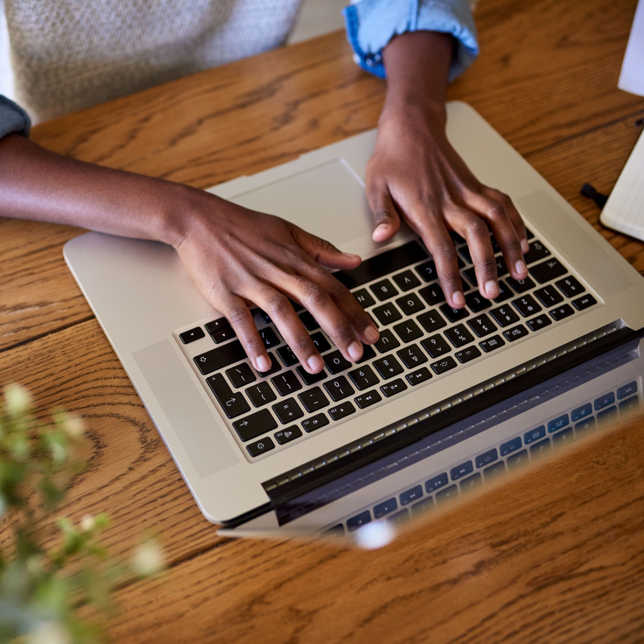 Closeup of an African American female entrepreneur working online with a laptop while sitting at a table at home  ; Shutterstock ID 1317157079; Purchase Order: N/A