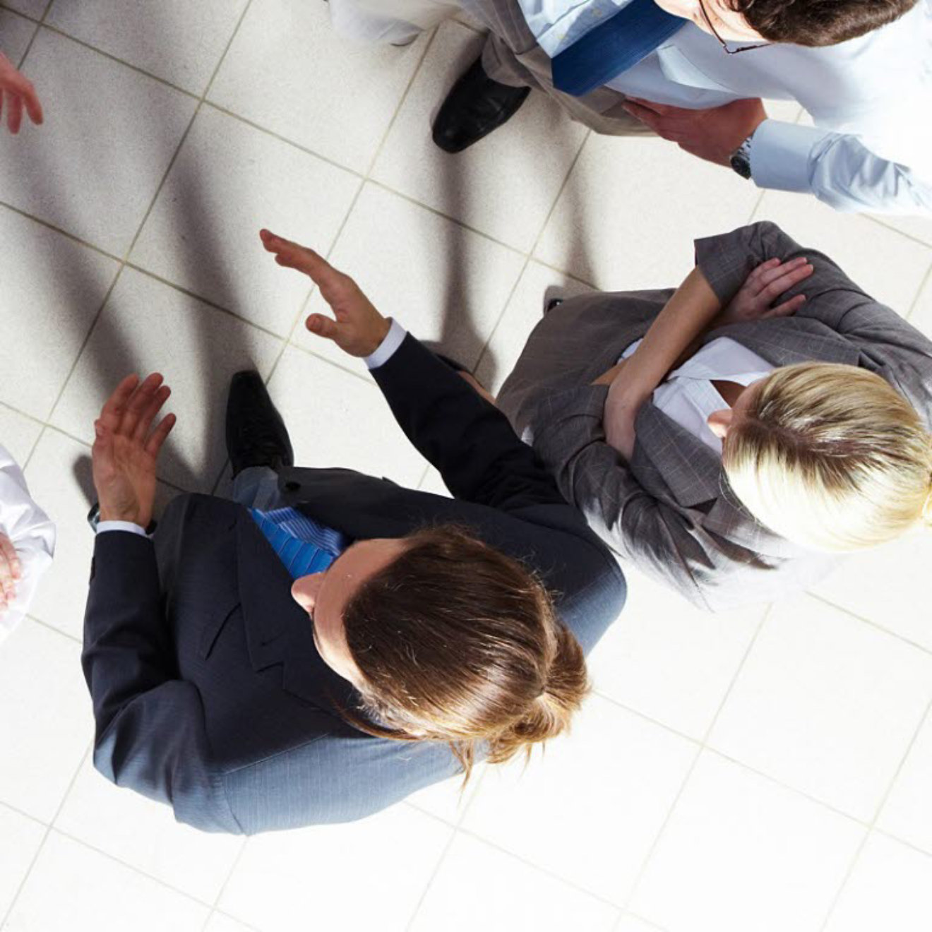 A small group of people meeting and shaking hands as viewed from above