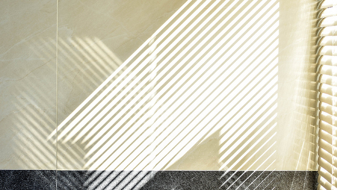 Abstract of morning light and shadow on tiled wall through window blind shutter