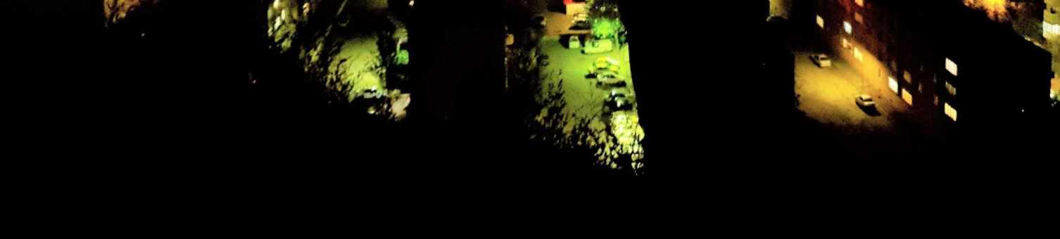 A nighttime aerial view of cars parked in the street