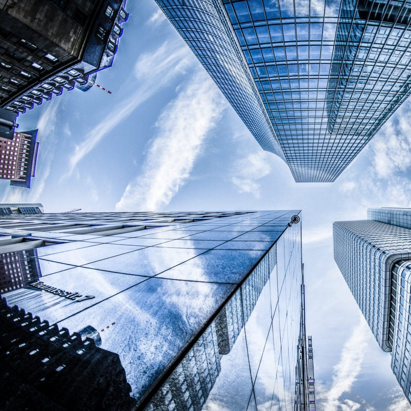 A view looking up towards the sky with skyscrapers on all sides