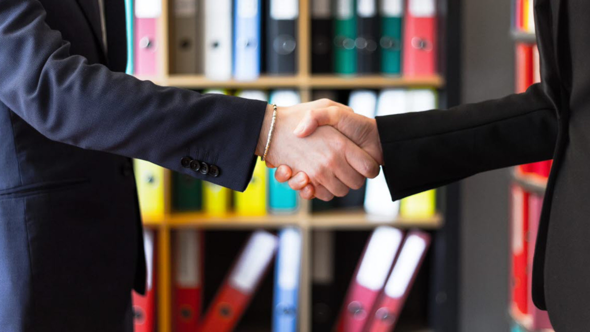 Two businesspeople shaking hands in an office