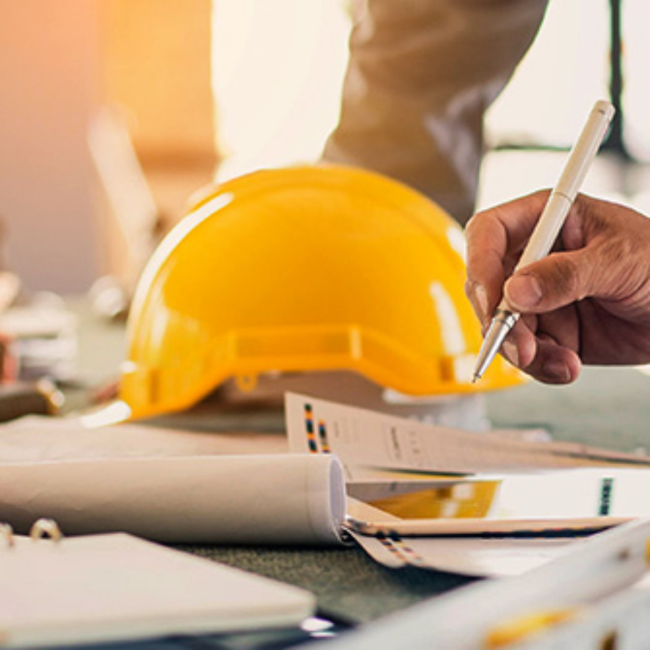 A trio of people on a construction site are looking at a blueprint