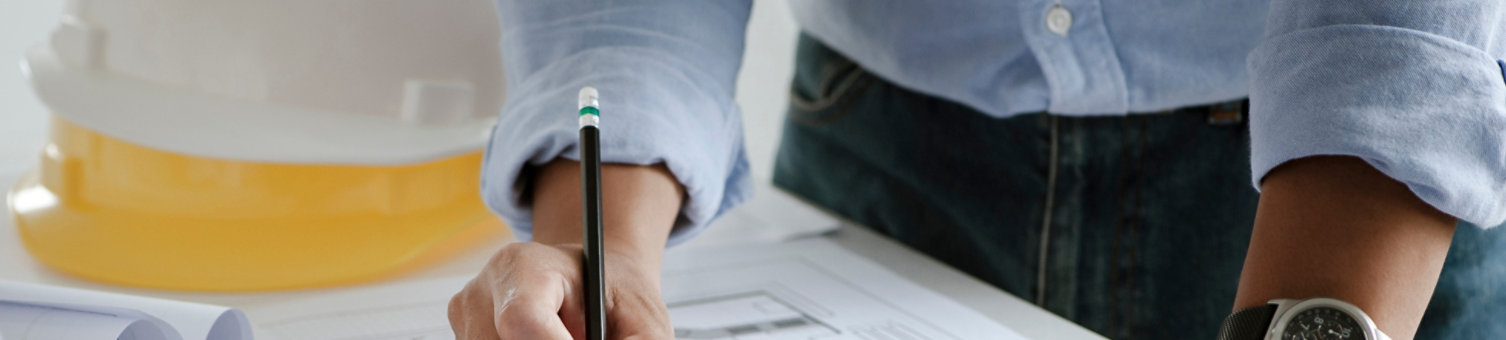 A close up of a surveyor, architect or engineer, working on drawings