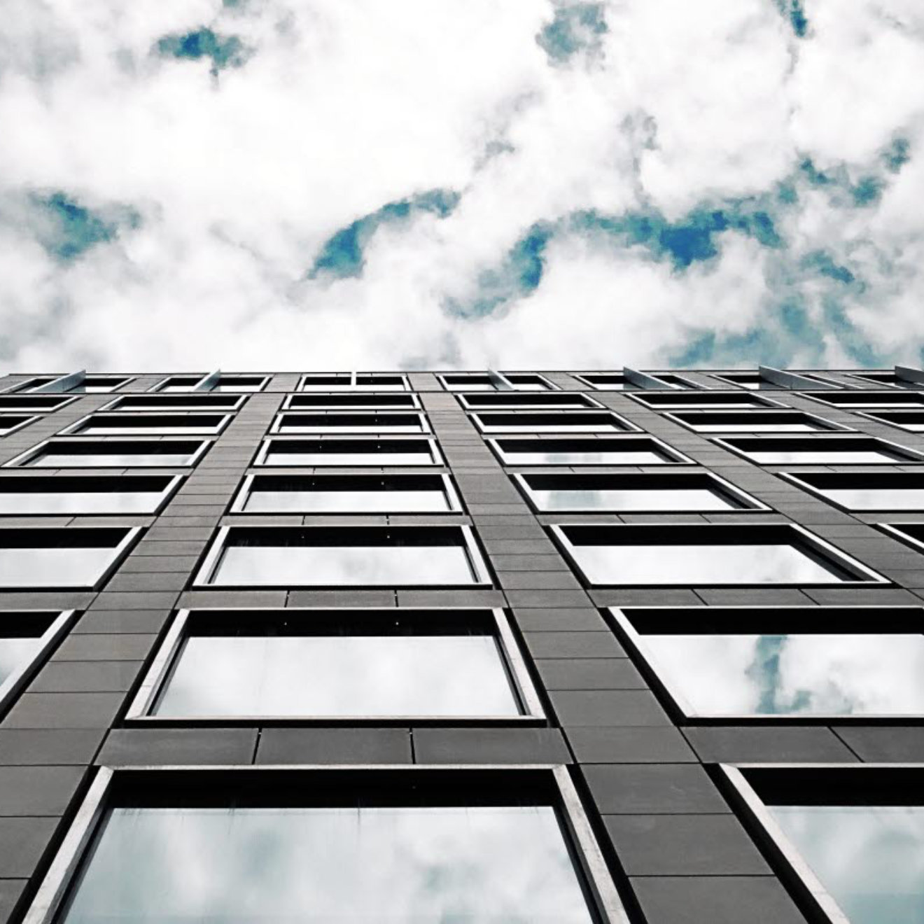 A photograph of the external wall of a high rise office taken from a worms-eye view