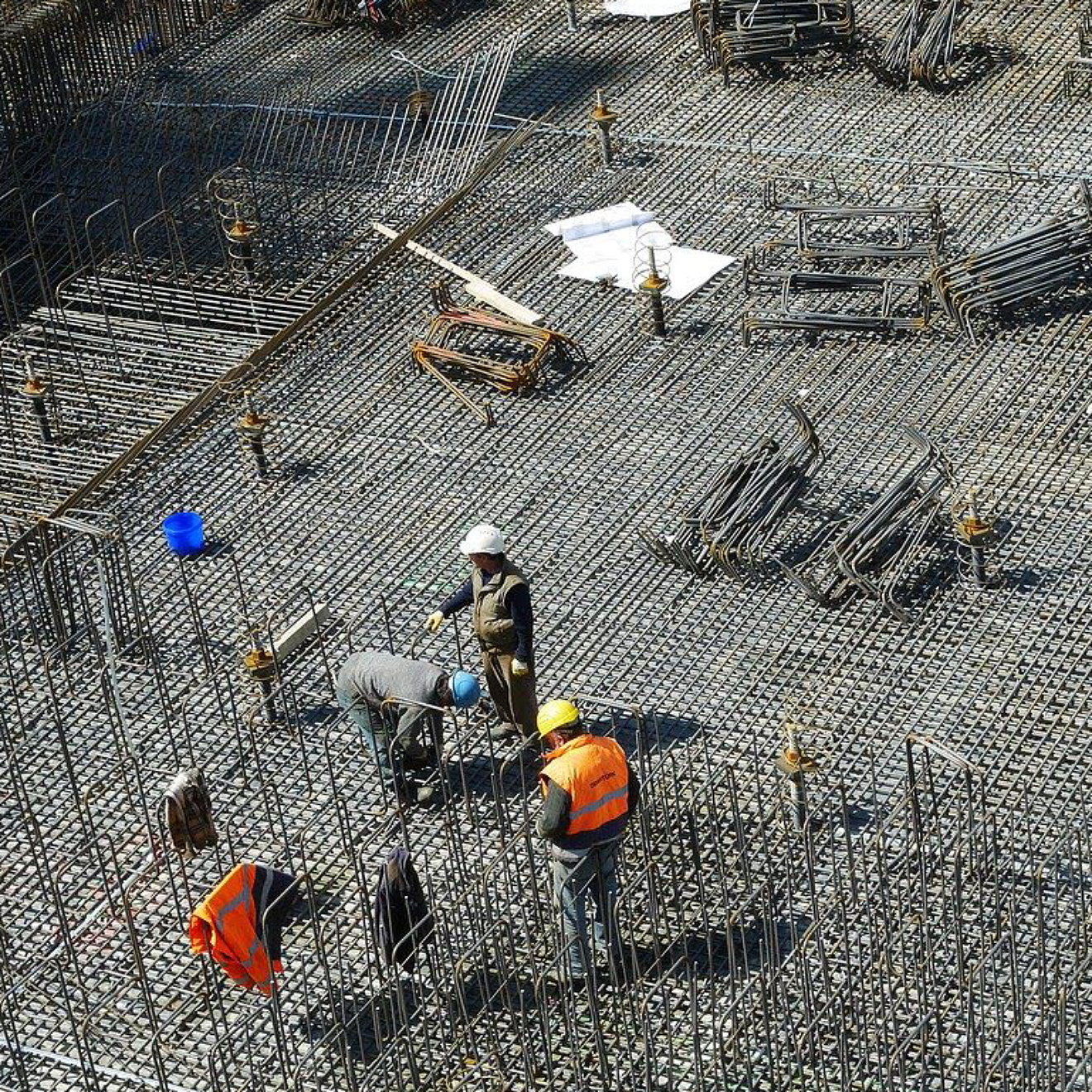 Workers looking at plans on the building site of a large building under construction