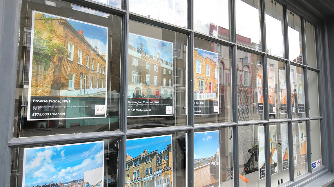 A high street estate agent's window displaying multiple property listings