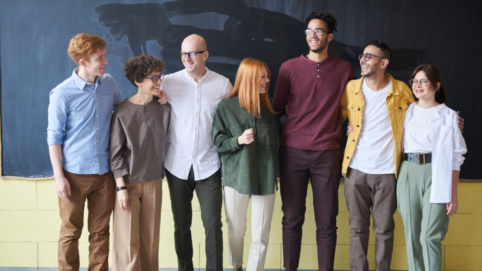 Group of people standing next to a chalk board