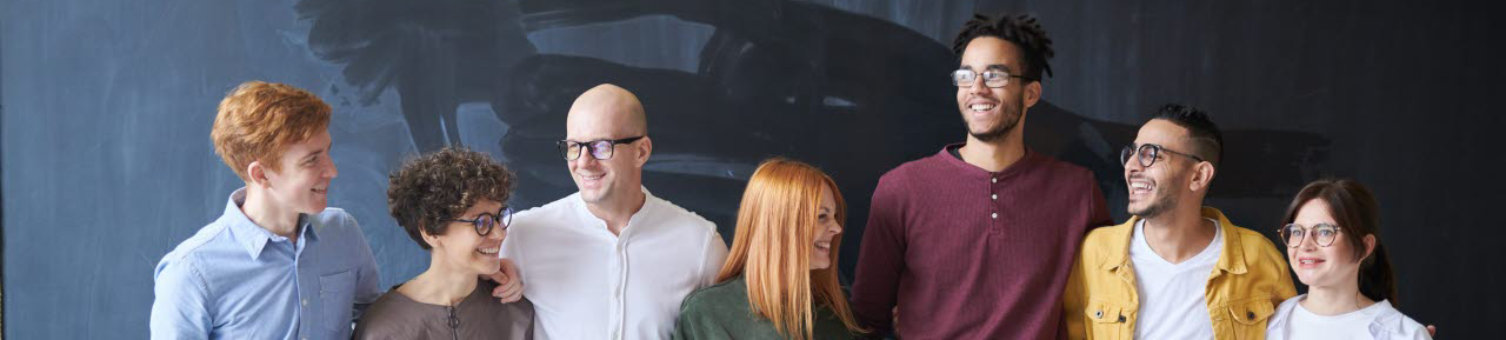 Group of people standing next to a chalk board