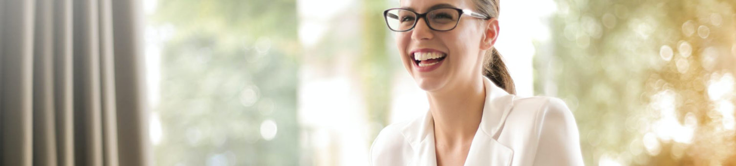 laughing-businesswoman-working-in-office-with-lapt