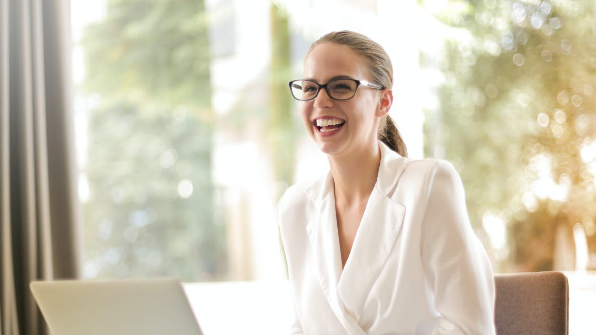 Laughing business woman with a laptop