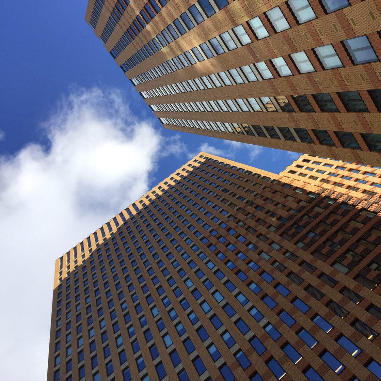 A view of a brick high-rise building taken from a low angle looking up