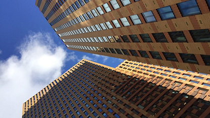 A view of a brick high-rise building taken from a low angle looking up