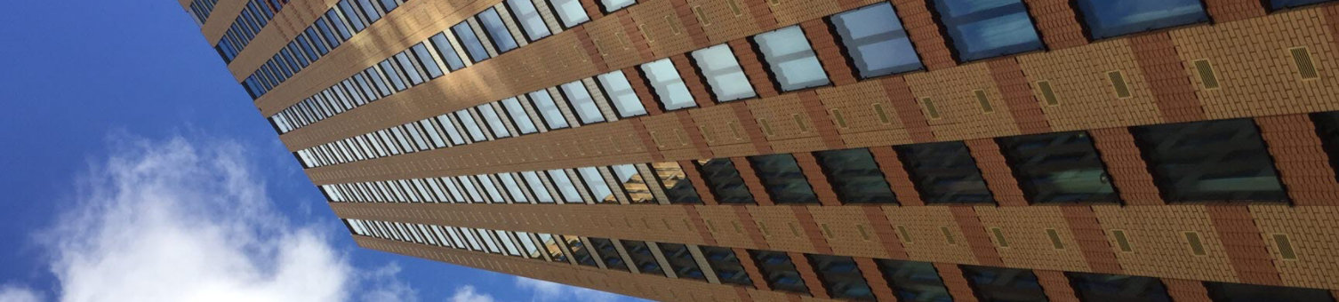 A view of a brick high-rise building taken from a low angle looking up