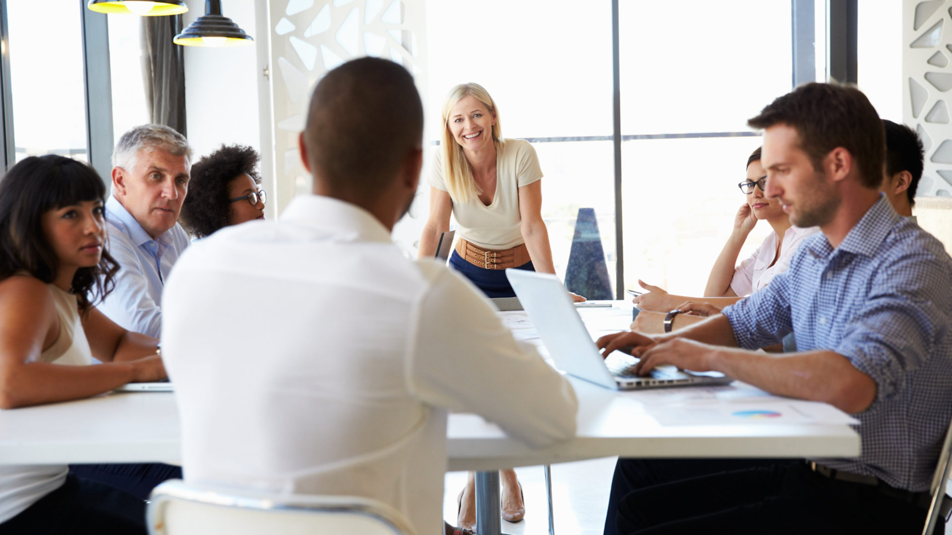 A group of professionals around a meeting table holding a friendly discussion