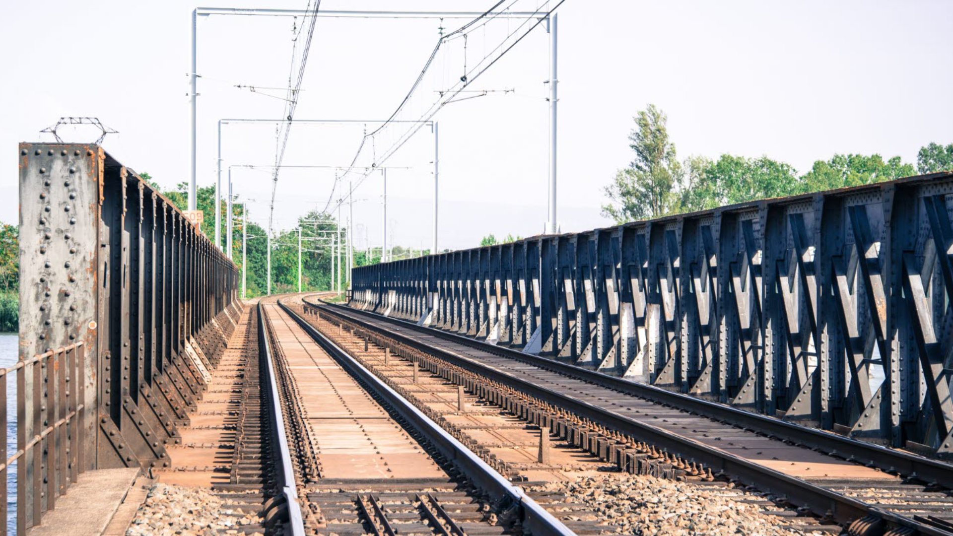 A view along the tracks of a small metal railway bridge