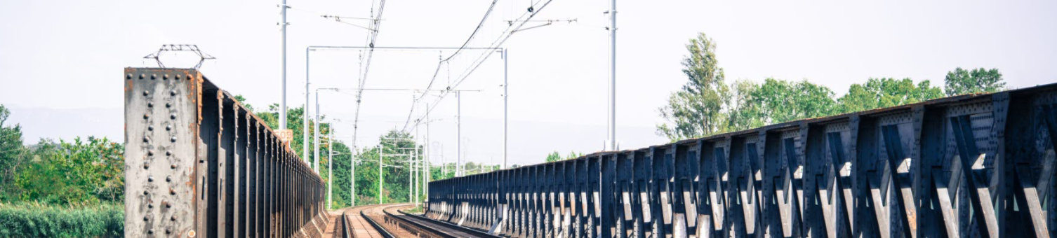 A view along the tracks of a small metal railway bridge