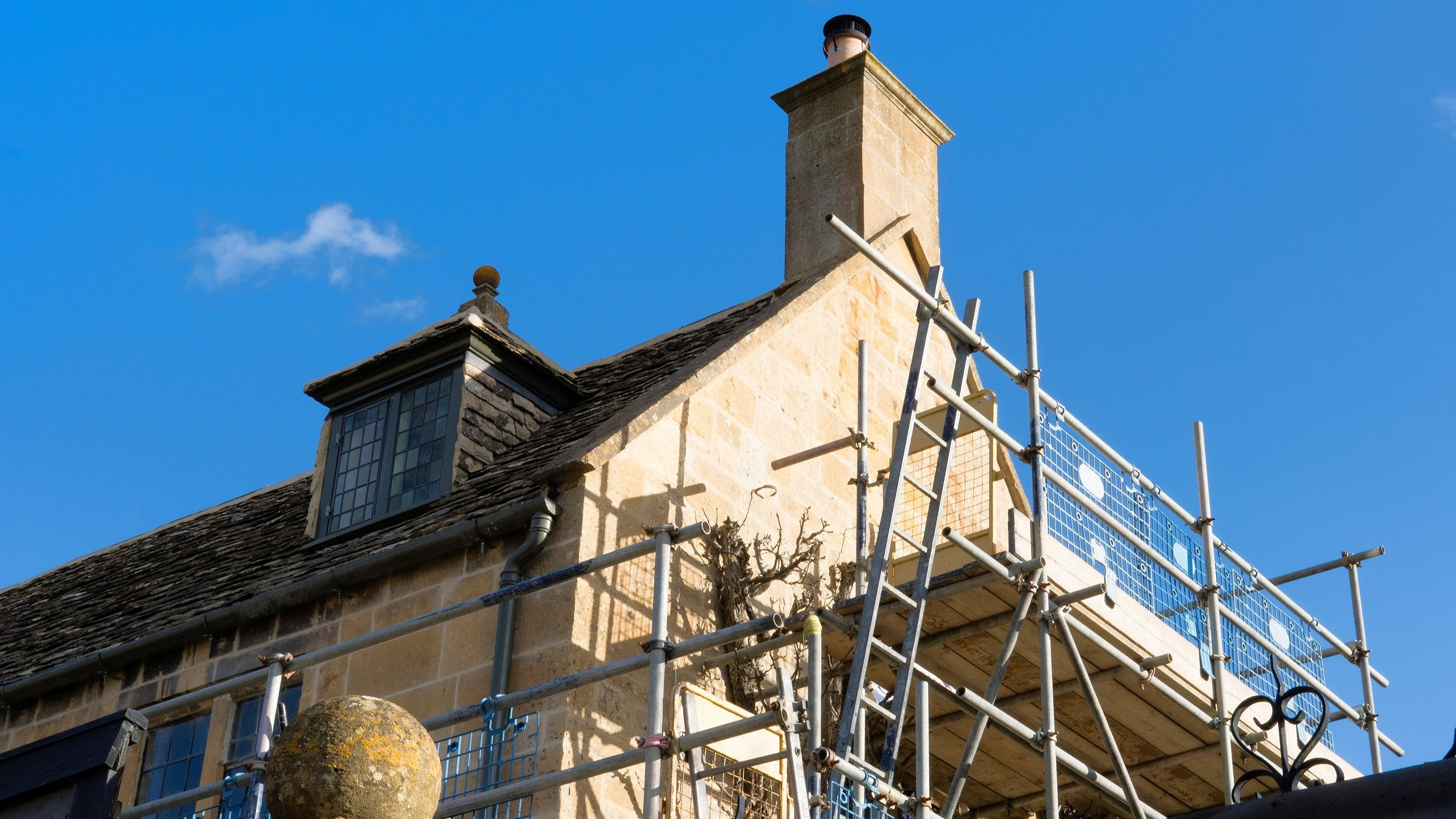 Scaffolding on an old traditional house in Broadway, Worcestershire, Cotswolds, UK