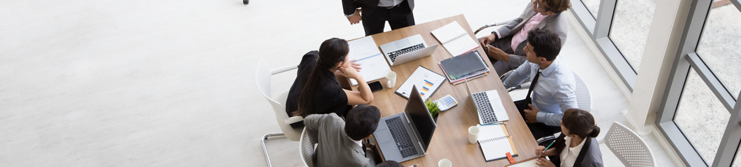 A man presenting to a seated group in a meeting environment