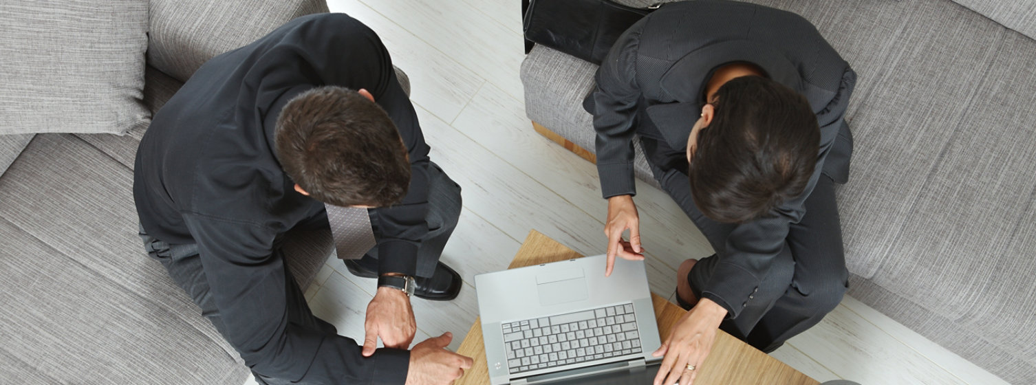 Business people sat at a small meeting table having a conversation