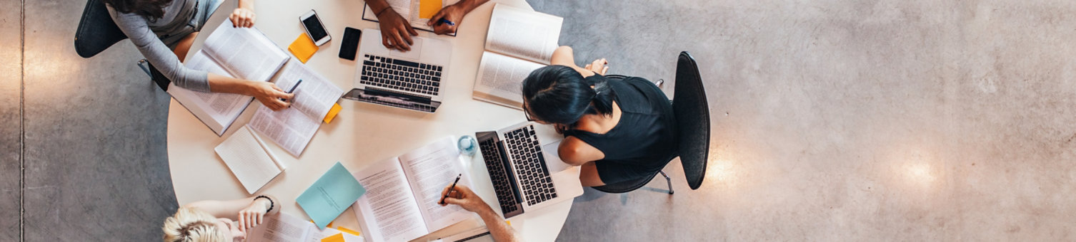 Top view of group of students sitting together at table. University students doing group study.; Shutterstock ID 506137015; purchase_order: N/A; job: Website Update March 22; client: RICS_PP; other: 