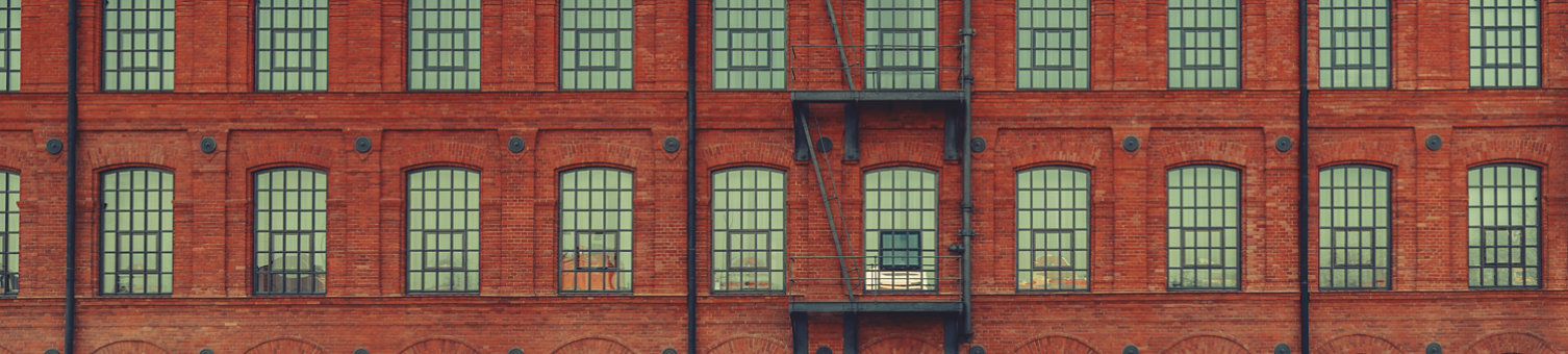 Huge red brick classic industrial building facade with multiple windows and fire escape ladder stairs. Industrial background. Loft inspiration. Construction facade concept. Vintage effect.; Shutterstock ID 642174928; purchase_order: -; job: -; client: -; other: -