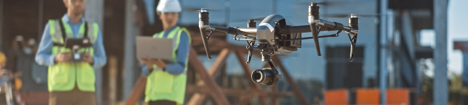 Diverse Team of Specialists Pilot Drone on Construction Site. Architectural Engineer and Safety Engineering Inspector Fly Drone on Commercial Building Construction Site Controlling Design and Quality