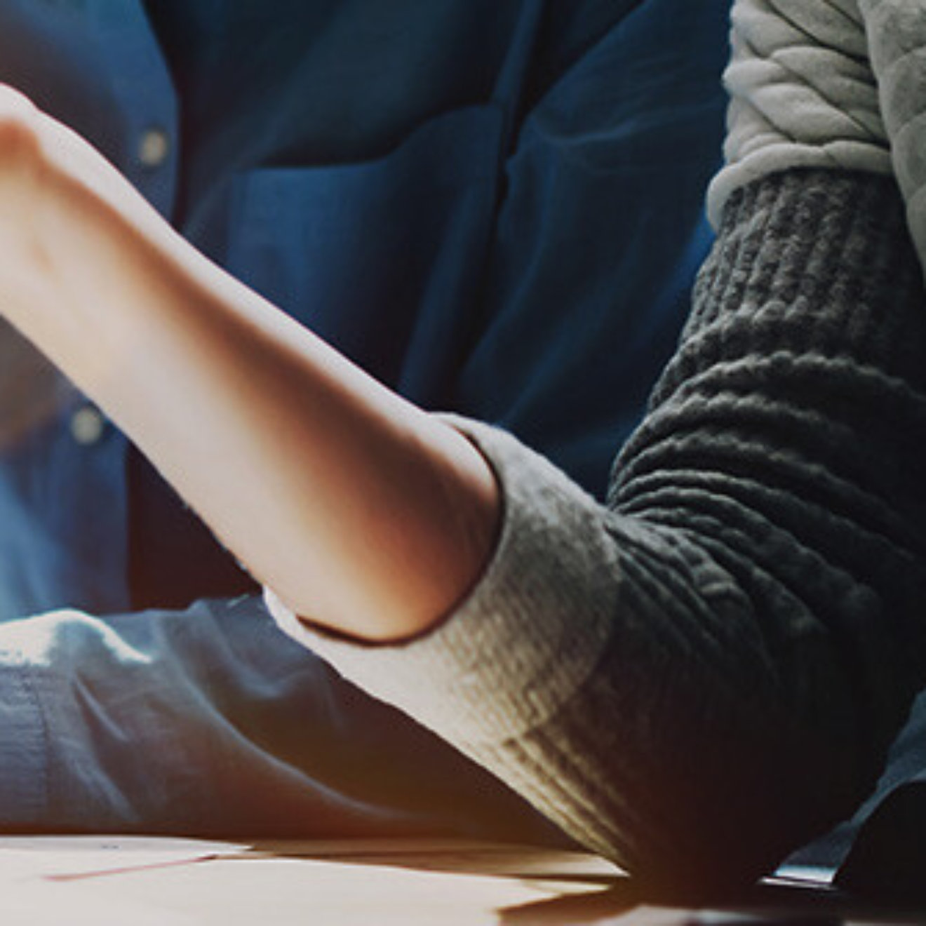 Business meeting time. Photo young account managers crew working with new startup project. Notebook on wood table. Idea presentation, analyze plans. Wide,film effect