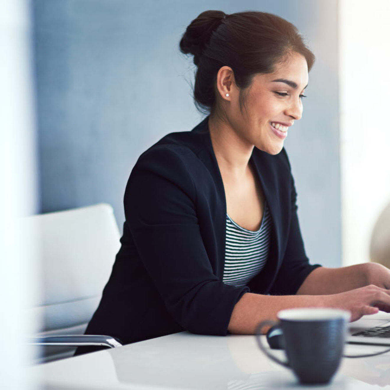 Woman in business clothing using a laptop