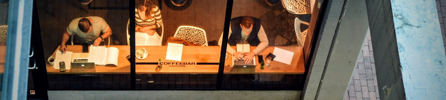 Workers in an office environment viewed through a window