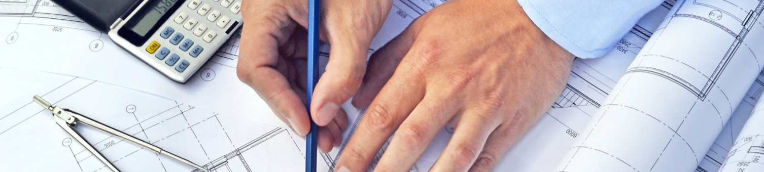 A photograph of a man's hands as he is inspecting architectural drawings